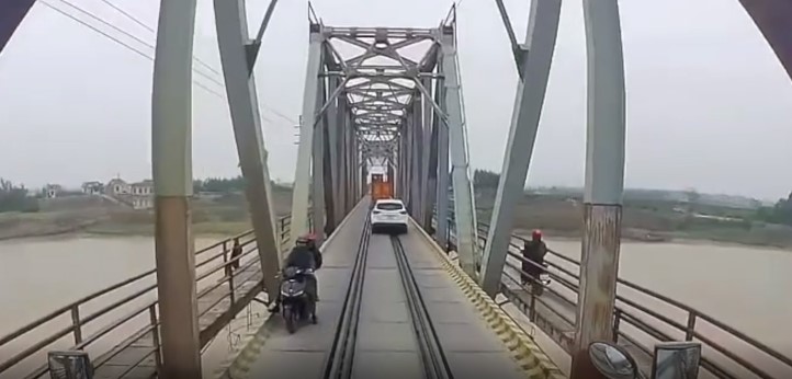 Cố tình đi vào đường cấm trên cầu, xe máy 'đối đầu' container